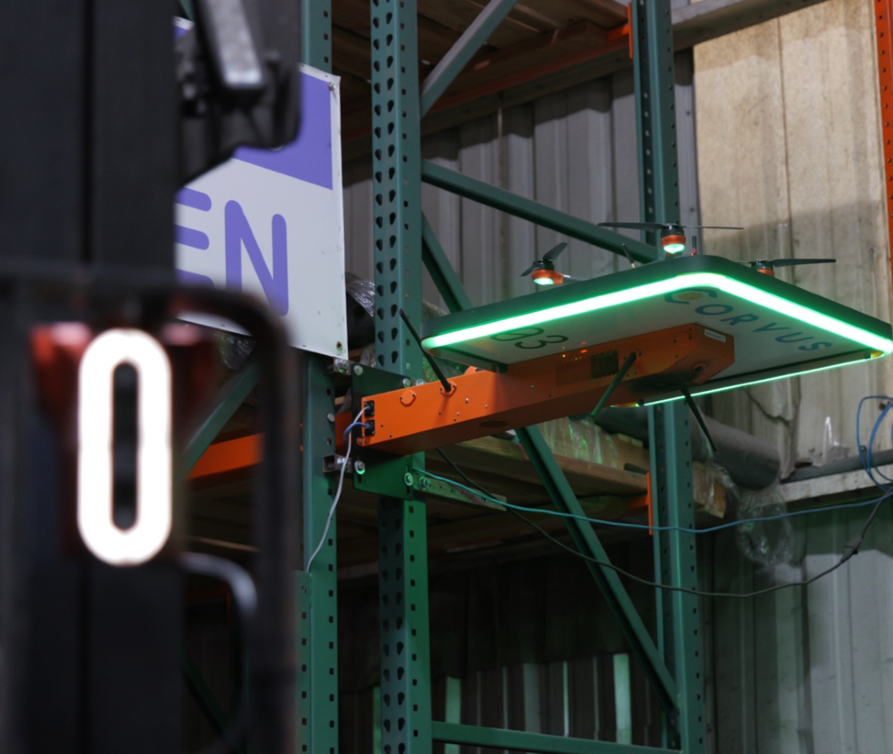 Corvus Trident on a forklift and Corvus One autonomous drone in a warehouse, showing unified inventory tracking across pallet movement and storage.